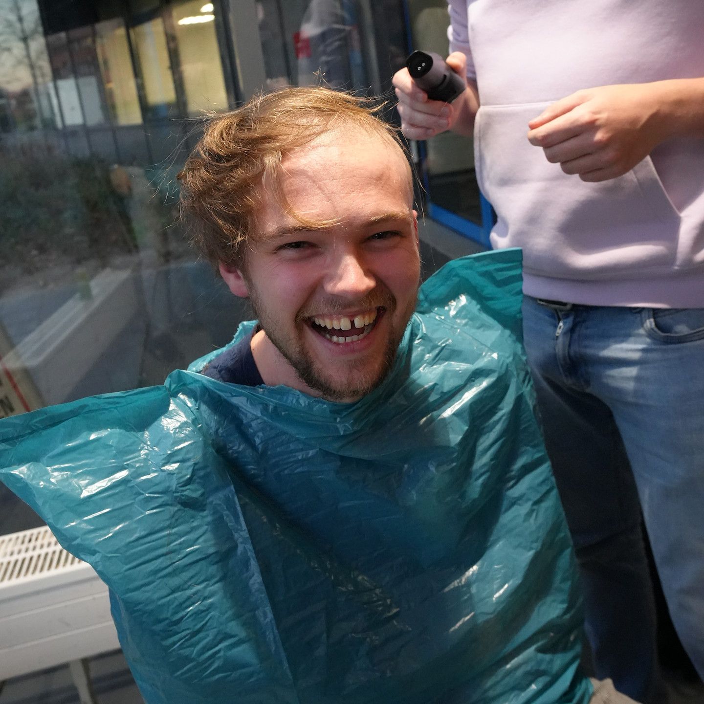 Pim tijdens het scheren met een vuilniszak als kappersjasje